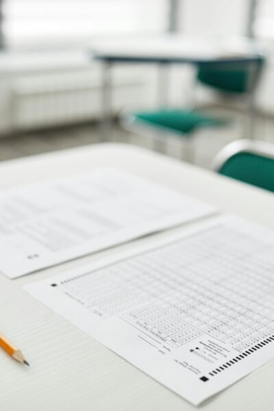 Close-up of exam papers and a pencil on a classroom desk, ready for a test.